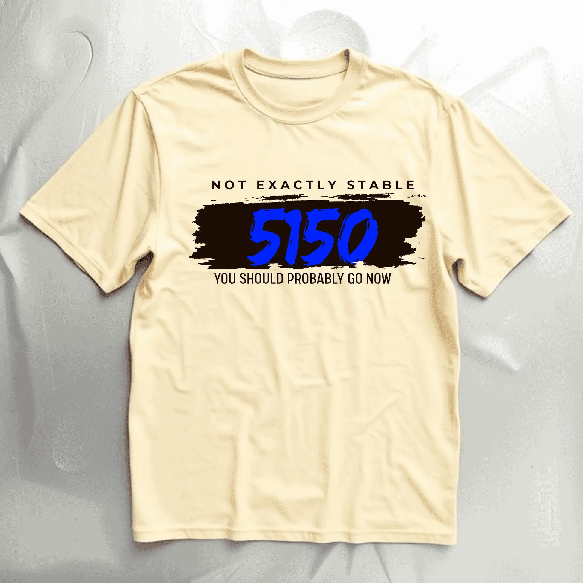 Beige t-shirt with text and 5150 signifying loss of sanity design on front  a gray background

